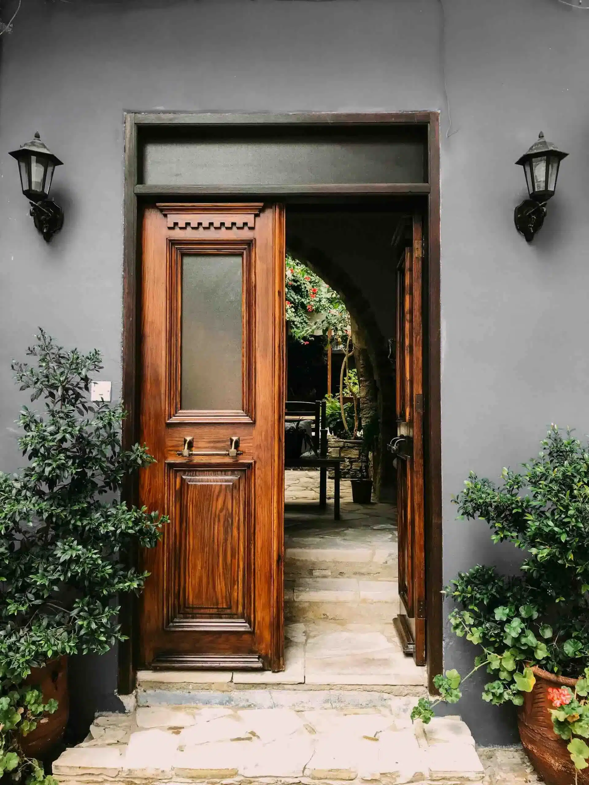 Roofing Brown wood-look entry door open to courtyard - Lindholm Exteriors