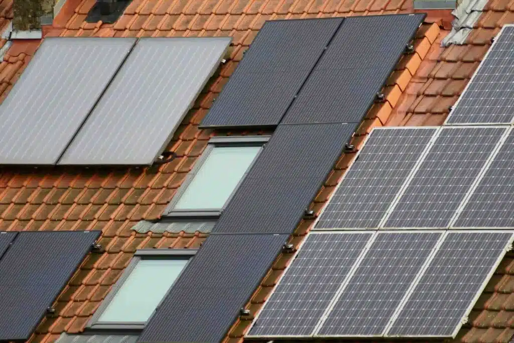 Gray and black solar panels on tiled roof, showcasing sustainable energy solutions - Lindholm Exteriors