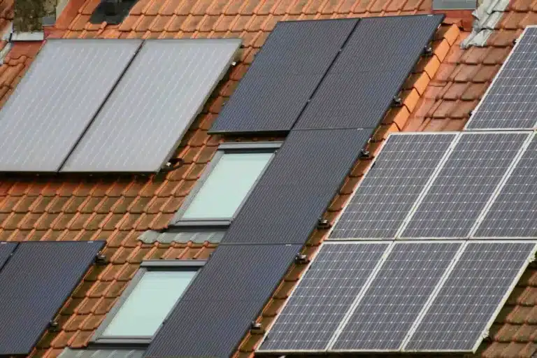 Gray and black solar panels on tiled roof, showcasing sustainable energy solutions - Lindholm Exteriors
